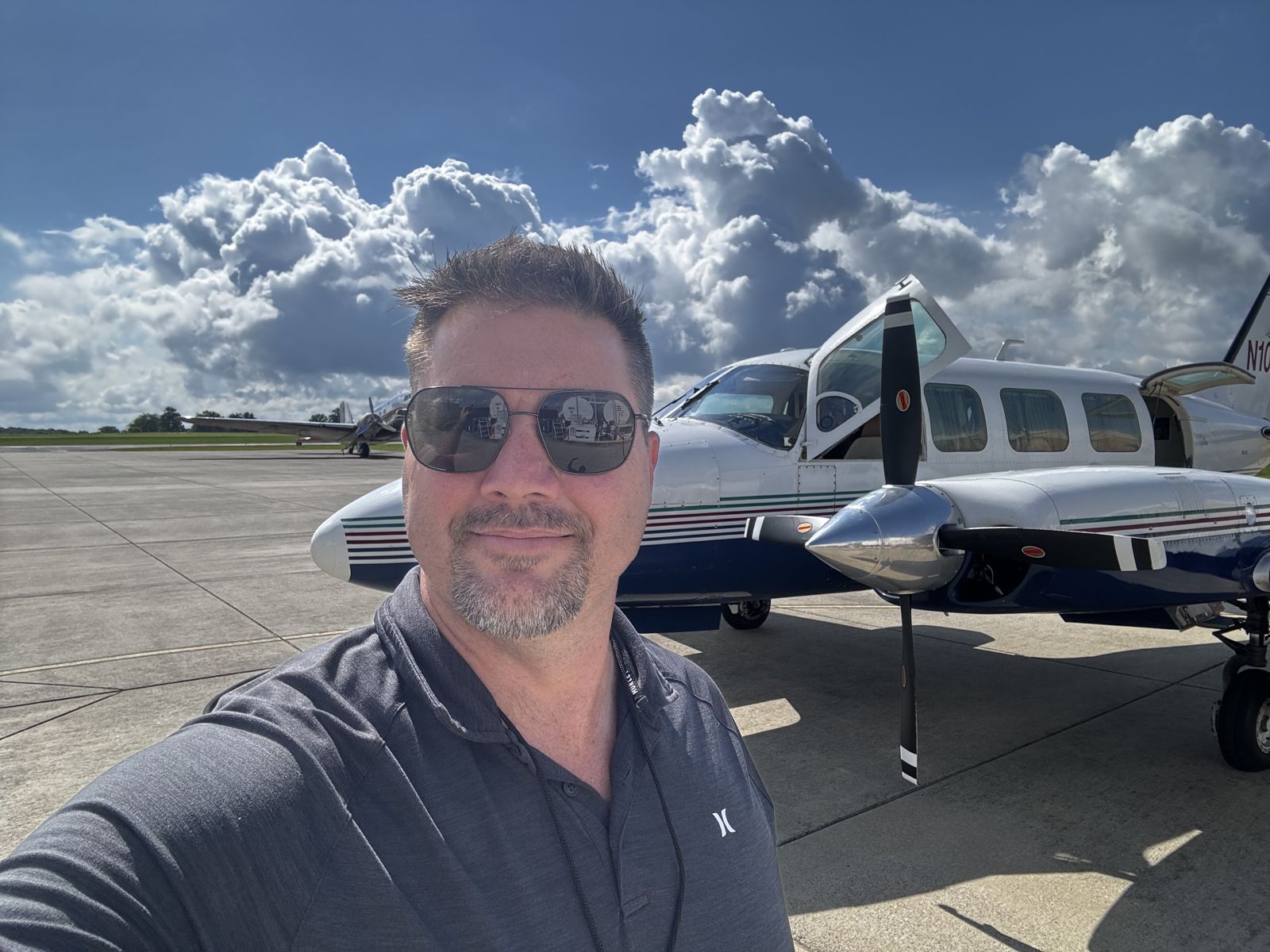 Piston twin on the ramp under big clouds